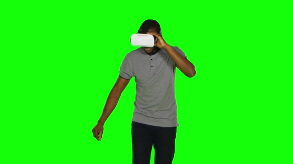 Man in the VR Mask Something Crosses Legs in the Air. Green Screen alt