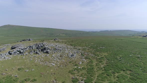 Wide shot aerial tracking forward over Bonehill Rocks, Dartmoor, Devon, England. alt
