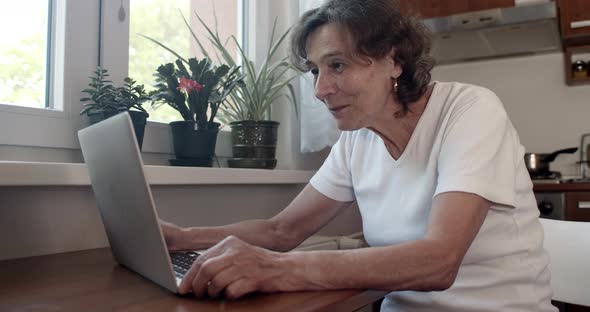 Senior Woman Chatting Online on Notebook