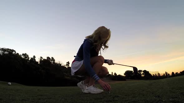 A woman playing golf alt