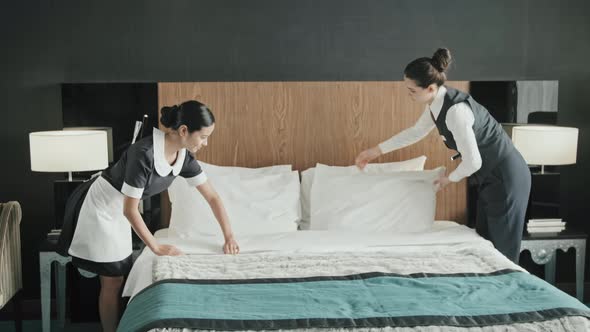 Hotel Employees Making Bed in Room alt