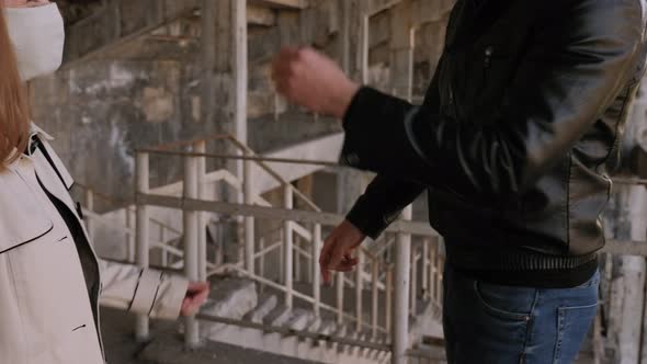 Couple in Protective Medical Masks Hitting Their Elbows Instead of Shaking Hands alt