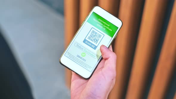 Pomeranian with yellow fur sitting on the snow and rising paw on the backyard. Snowflakes falling on alt