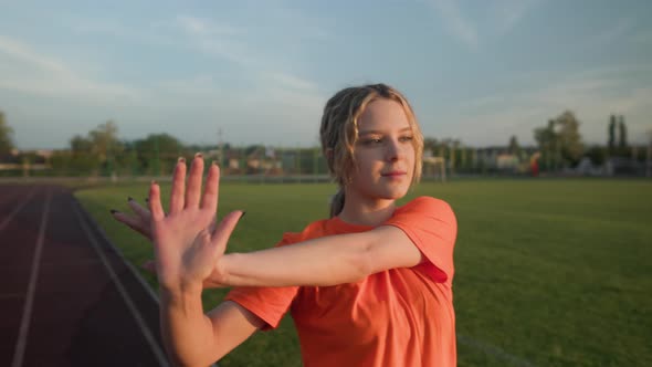 Young Beautiful Girl in Sweatpants and an Orange Tshirt Goes in for Sports alt
