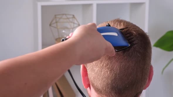 A Man Cuts His Hair with Clipper