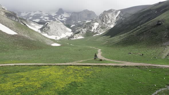 Green plateau among snowy mountains