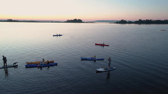 Aerial Drone Footage. A Group of Tourists Are Kayaking. Beautiful Sunrise Over River alt