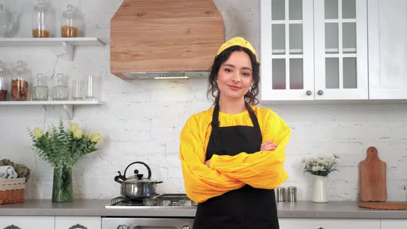 Portrait Smiling Woman Housewife Looking Camera Crossed Hands in Home Kitchen alt