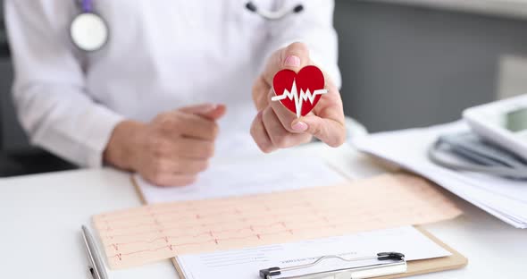 Doctor Cardiologist Holding Heart Shaped Icon with Ecg and Showing Thumb Up  Movie alt