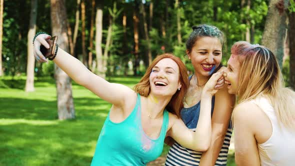 Selfie Time of Female Friends Covered with Colorful Powder after Holi Festival alt