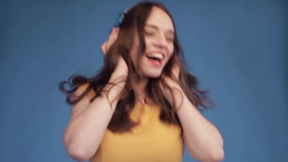 Young Girl in Yellow Shirt and Headphones Listening Music