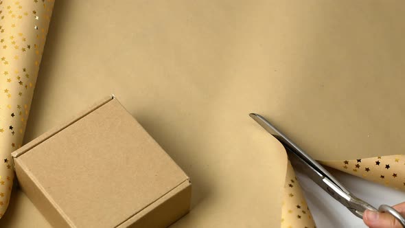 Women wrapping gifts in festive paper. Christmas paper for wrapping presents alt