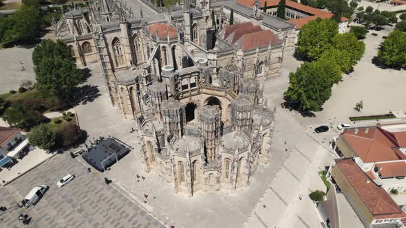 Aerial pan shot around monument of unfinished chapel Capelas Imperfeitas in Batalha, Portugal. alt
