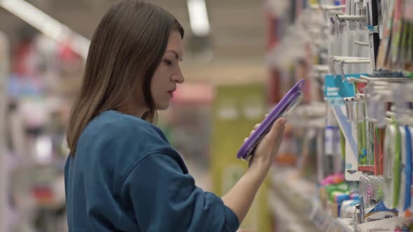 Young Woman Buying Stationery Mother Choose Pens and Tools in a Supermarket for Her Children alt