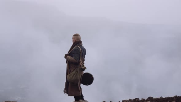 Man In Greatcoat Standing In Misty And Rocky Landscape alt