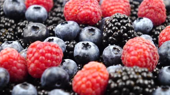 Ripe raw berries of raspberry, blackberry and bog whortleberry, background