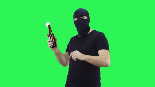A man in a black mask holds a bottle with a prosperous mixture in his hand