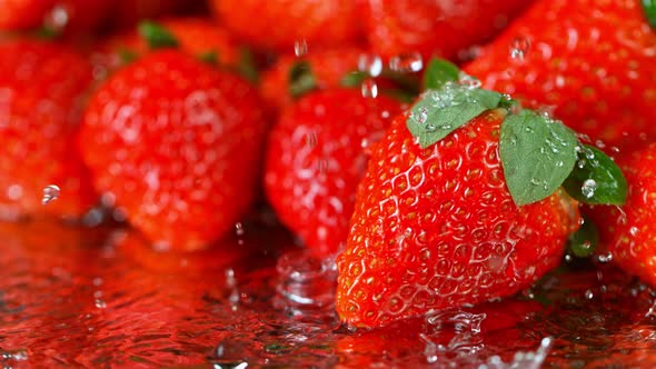 Super Slow Motion Shot of Water Splashing on Fresh Strawberries at 1000Fps alt