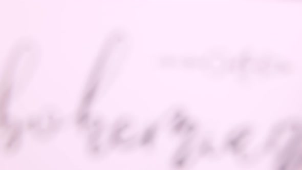 Hands with BOHEMIAN handwritten card over a wooden table top view alt