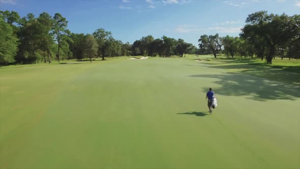 Man Walks Golf Course Aerial Shot