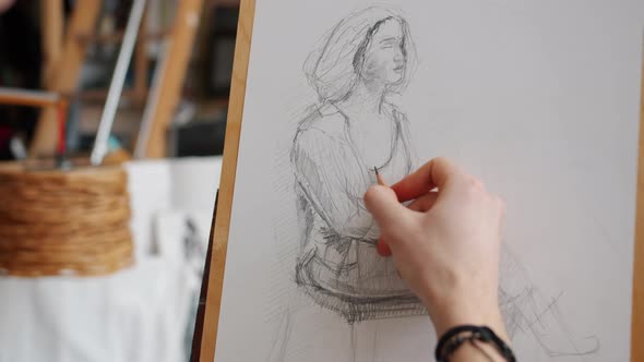 Close-up of Man's Hand Sketching Portrait of Woman During Lesson in Art School alt