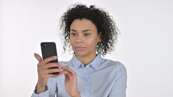 Portrait of Cheerful Young African Woman Celebrating on Smartphone alt