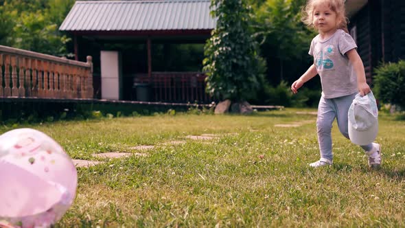 Tracking Little Cute Baby Runs Around Lawn and Kicks the Ball alt