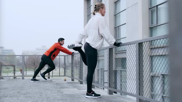 Two athletes doing warm up stretches in winter before training