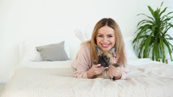 Young Woman in a Cozy Powder Pink Sweater and White Stockings Lying on the Bed alt