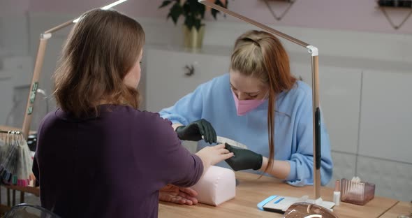 Beautician Manicurist Does Procedure of the Cropp Manicure By Special Drilling Tool Cosmetological