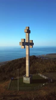 drone view flies around stone or concrete cross high in mountains alt