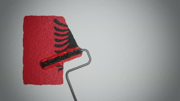 Roller paints the wall in colors of  Albanian flag. alt