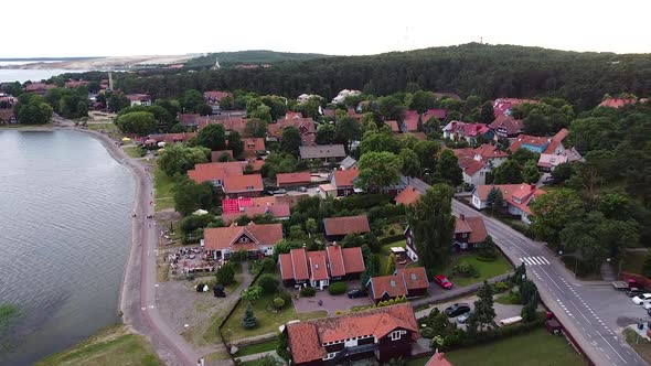 Nida town in Neringa, Lithuania in aerial drone ascending to high altitude view alt
