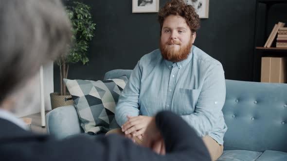 Adult Man with Strange Behavior Talking to Therapist During Session in Modern Office alt