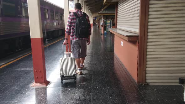 Tourists walk dragging luggage in the train station. Work and travel concept.