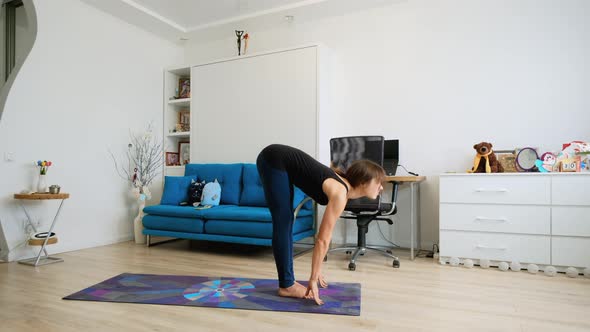 Young Woman Practicing Yoga At Home Warming Up
