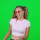 Caucasian Female Dances to the Music on a Green Background Cheerful Girl Takes a Video on for a - VideoHive Item for Sale