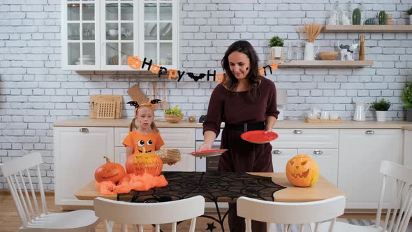 Daughter Helping Mother To Prepare for Halloween alt
