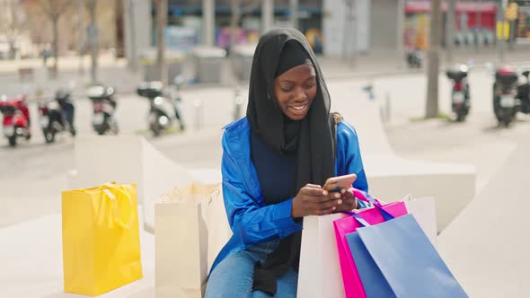 Muslim Shopper Texting on Smartphone alt