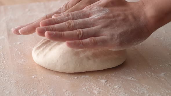 Camera follows man’s hands kneading a dough. Slow Motion. alt