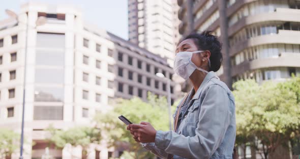 Mixed race woman wearing medical coronavirus mask on the street alt