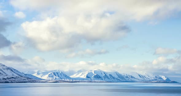 Cloud rolling time lapse over snow mountain fjords in Akureyri, Iceland. alt
