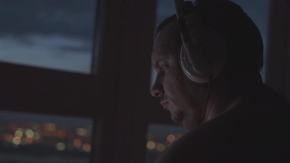 Close Up of Man in Headphones Playing Video Game at Home in Dark Room at Night Enjoying Gaming