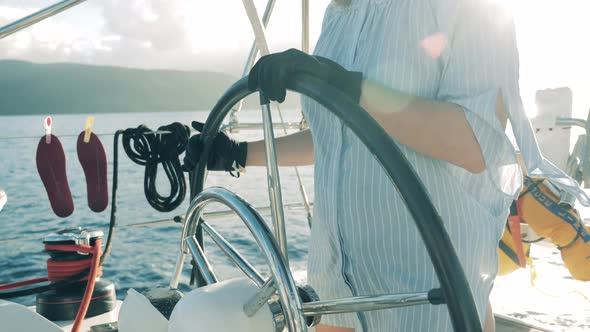 One Woman Holds a Helm While Sailing a Yacht alt
