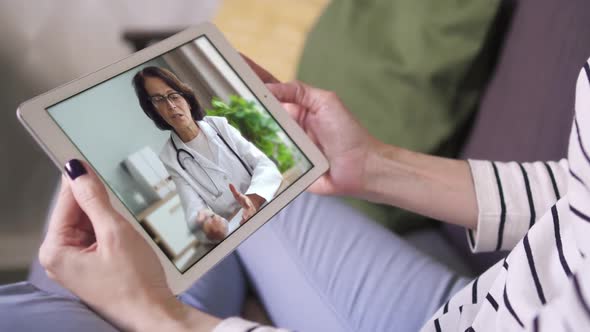 Online Video Call Via Tablet Female Doctor in White Lab Coat Consulting Her Patient