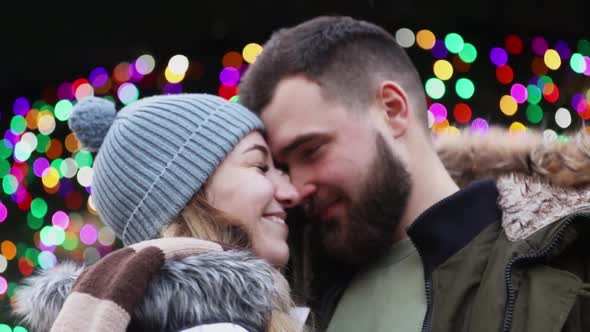 Beautiful couple, boyfriend and girlfriend are kissing on Christmas fair in Wroclaw, Poland alt