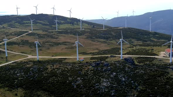 Aerial View Of Fast Spinning Windfarm Turbines In Hillside Of Galicia In Spain. Dolly Right alt