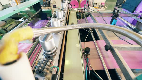 Plastic Bag Cutting Machine at a Plastic Bag Production Factory. Close Up alt