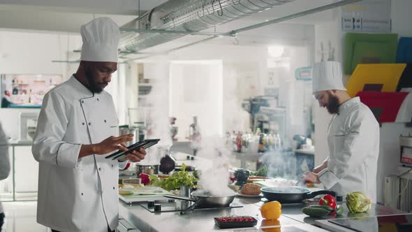African American Cook Searching Gourmet Recipe on Digital Tablet alt