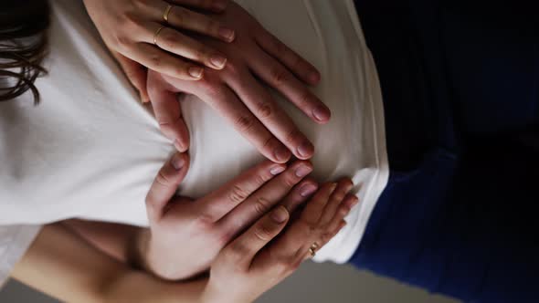 Happy Husband Hugging Belly of Pregnant Wife at Home alt